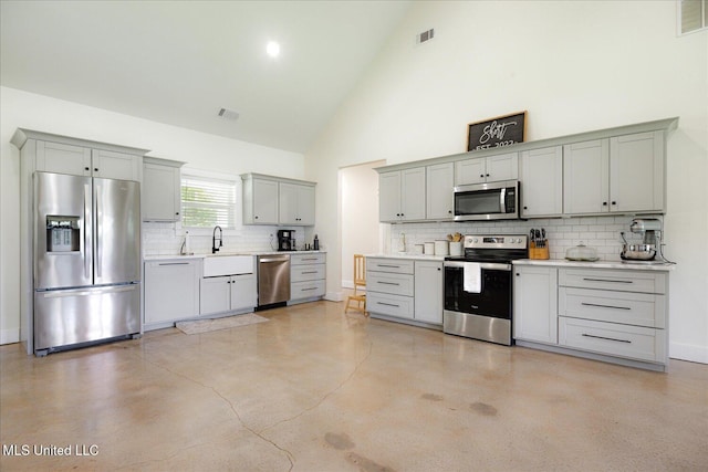 335 Aaron Rd, Sarah, MS 38665 - kitchen with appliances with stainless steel finishes, gray cabinetry, decorative backsplash, high vaulted ceiling, and light countertops