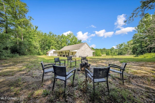 335 Aaron Rd, Sarah, MS 38665 - view of green lawn with an outdoor fire pit and a forest view