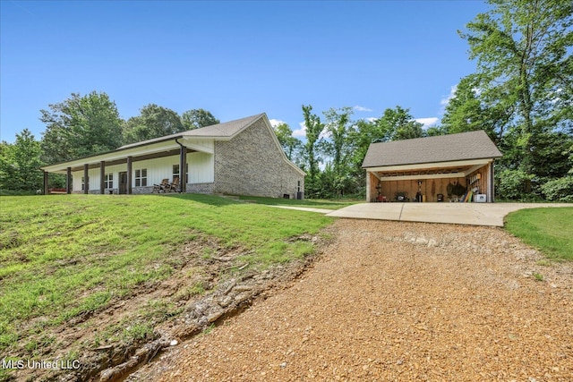335 Aaron Rd, Sarah, MS 38665 - view of side of property with driveway, a lawn, a carport, and an outbuilding