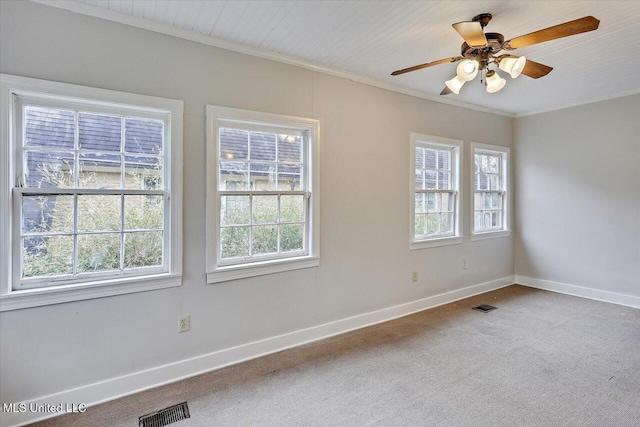 carpeted spare room featuring ornamental molding, visible vents, and baseboards