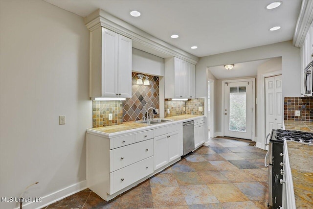 kitchen with a sink, white cabinets, baseboards, light countertops, and appliances with stainless steel finishes