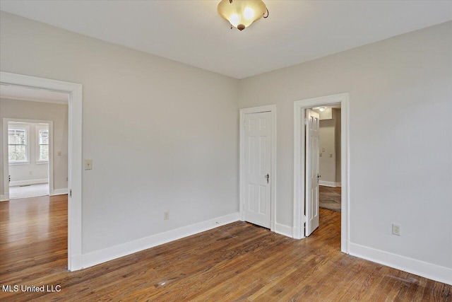 unfurnished room featuring dark wood-style floors and baseboards