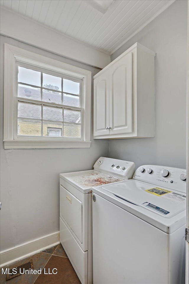 washroom featuring cabinet space, washer and dryer, wooden ceiling, dark tile patterned floors, and baseboards