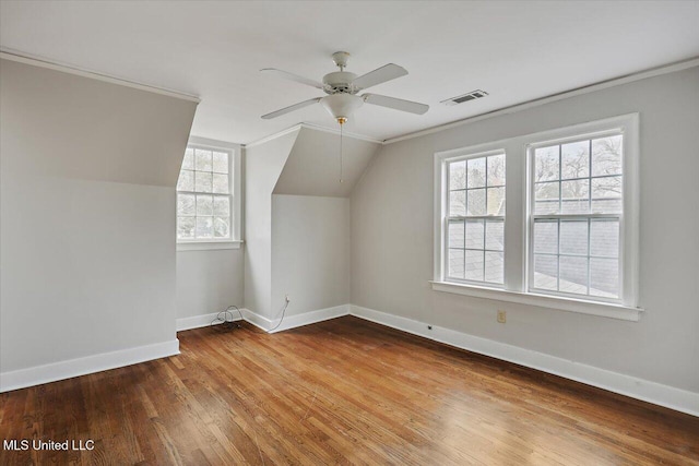 additional living space featuring lofted ceiling, visible vents, baseboards, and wood finished floors