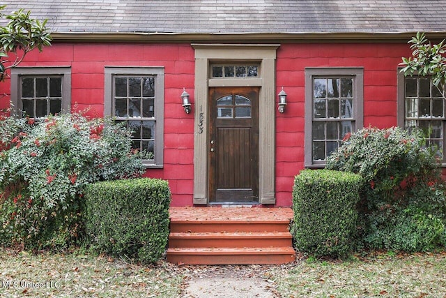 entrance to property featuring a shingled roof