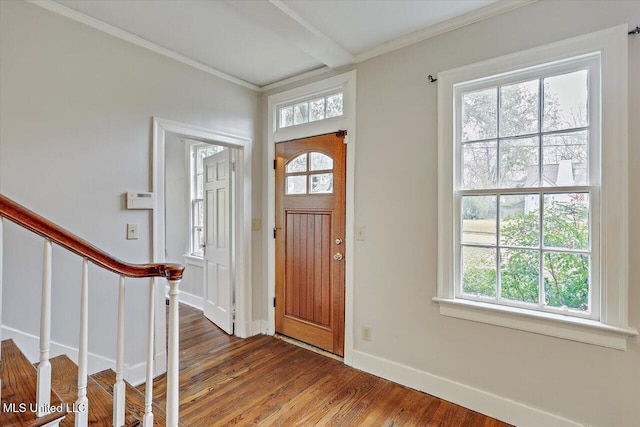 entrance foyer featuring dark wood-style floors, crown molding, baseboards, and stairs