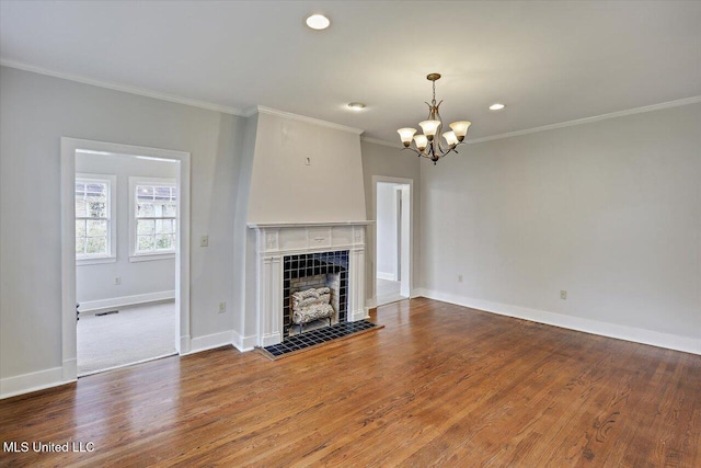 unfurnished living room with a tiled fireplace, wood finished floors, and crown molding