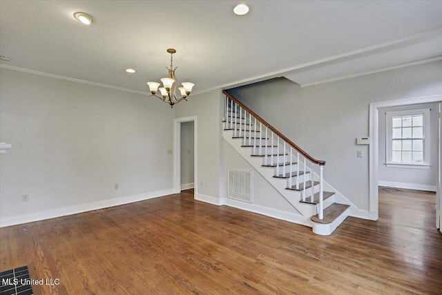 interior space featuring baseboards, visible vents, stairway, ornamental molding, and wood finished floors