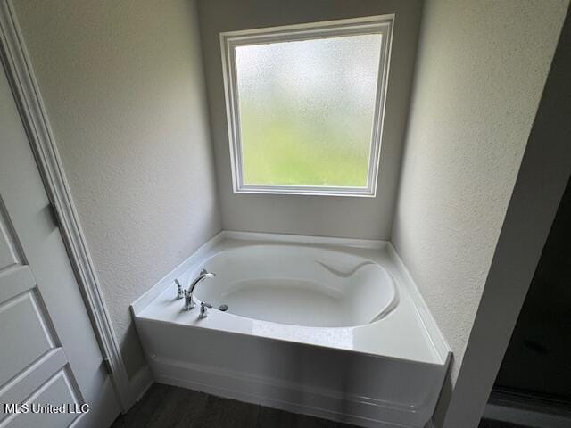 5378 Leeds Ln, Biloxi, MS 39532 - full bathroom featuring a textured wall, a bath, and wood finished floors