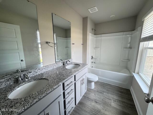 5378 Leeds Ln, Biloxi, MS 39532 - full bath with toilet, double vanity, wood finished floors, and bathing tub / shower combination