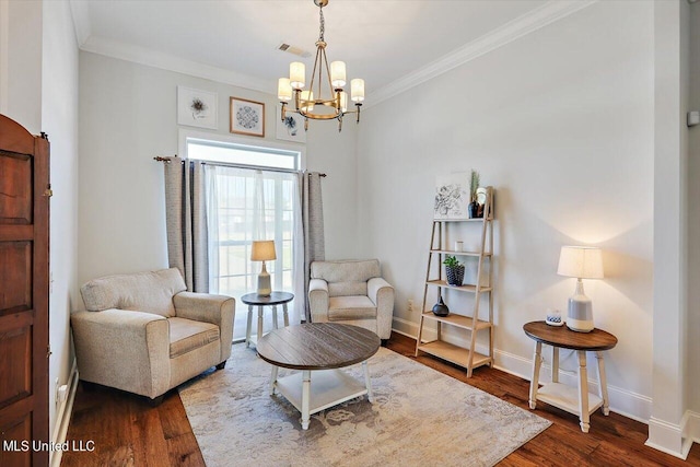 living area with wood-type flooring, ornamental molding, and an inviting chandelier