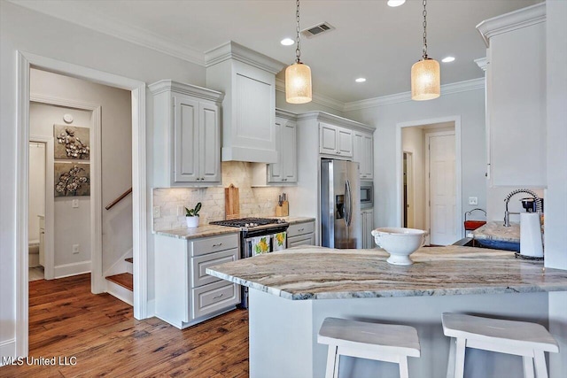 kitchen featuring kitchen peninsula, white cabinets, hanging light fixtures, dark wood-type flooring, and stainless steel appliances