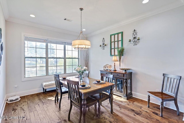 dining area featuring crown molding and hardwood / wood-style floors