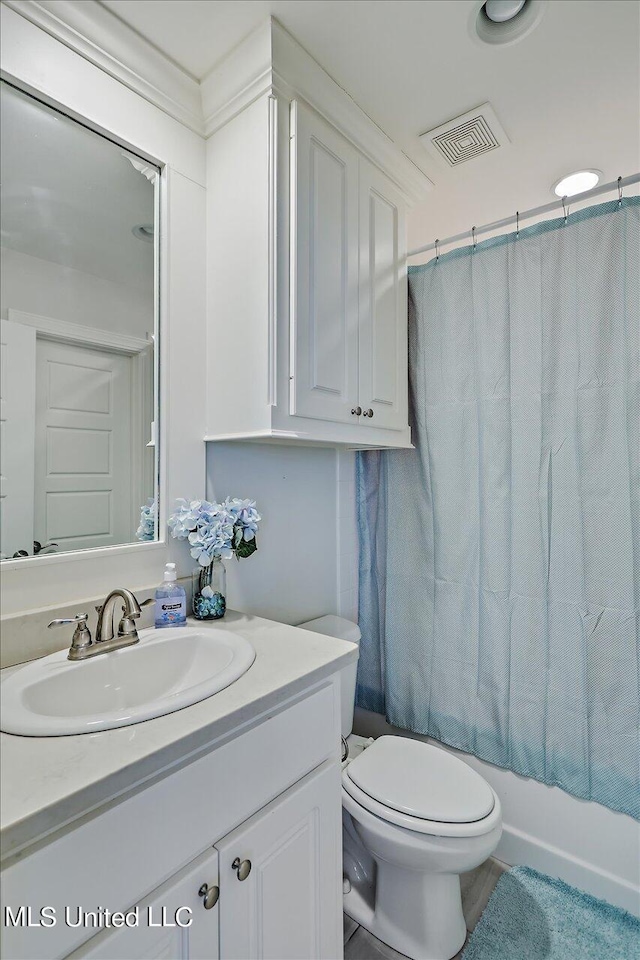 full bathroom featuring vanity, shower / tub combo with curtain, and toilet