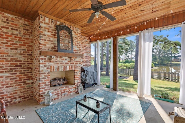 view of patio / terrace featuring grilling area, an outdoor brick fireplace, a water view, and ceiling fan