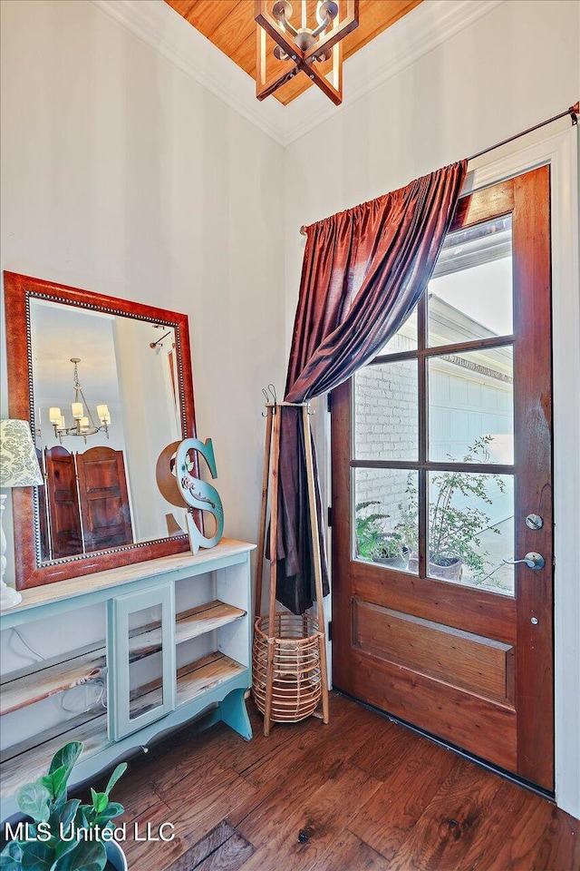 interior space featuring crown molding, an inviting chandelier, and dark hardwood / wood-style floors