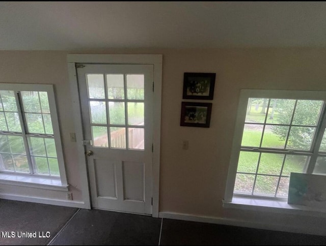 20454 Saucier Advance Rd, Saucier, MS 39574 - doorway to outside featuring baseboards, dark tile patterned floors, and a wealth of natural light