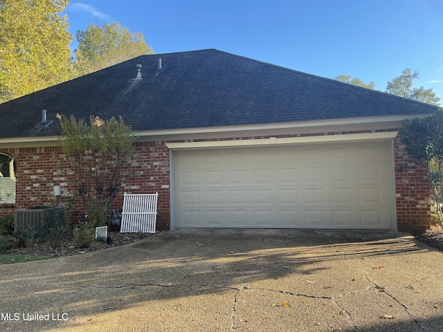 exterior space with a garage and cooling unit