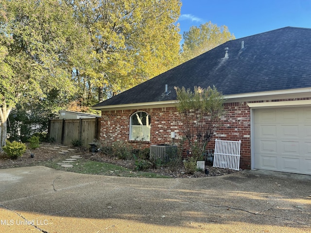 view of front of property with cooling unit and a garage