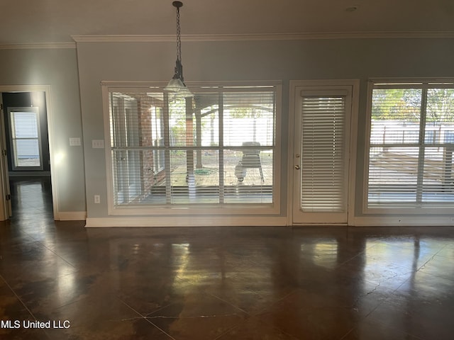 unfurnished dining area featuring crown molding, plenty of natural light, and dark tile patterned flooring