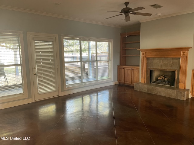 unfurnished living room with dark tile patterned floors, built in features, a wealth of natural light, and a tiled fireplace