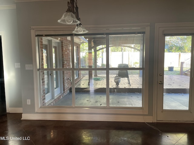 doorway featuring dark tile patterned flooring and crown molding