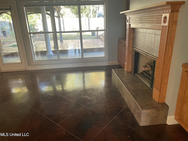 unfurnished living room featuring a tiled fireplace and dark tile patterned floors