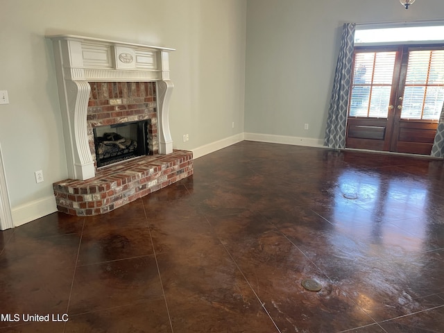 unfurnished living room featuring french doors and a brick fireplace