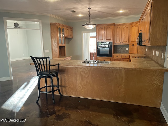 kitchen featuring backsplash, kitchen peninsula, sink, and black appliances