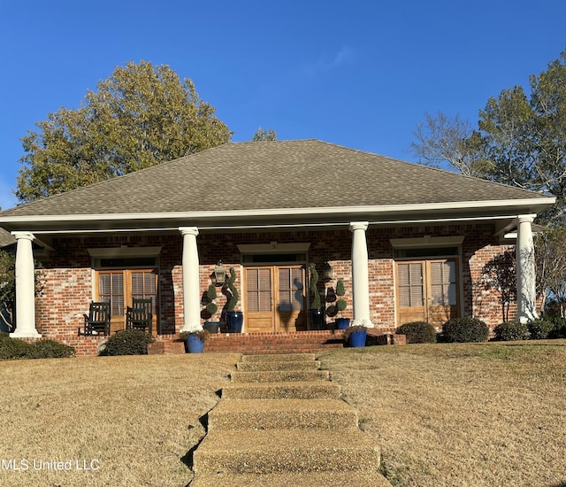 rear view of property with a lawn and covered porch