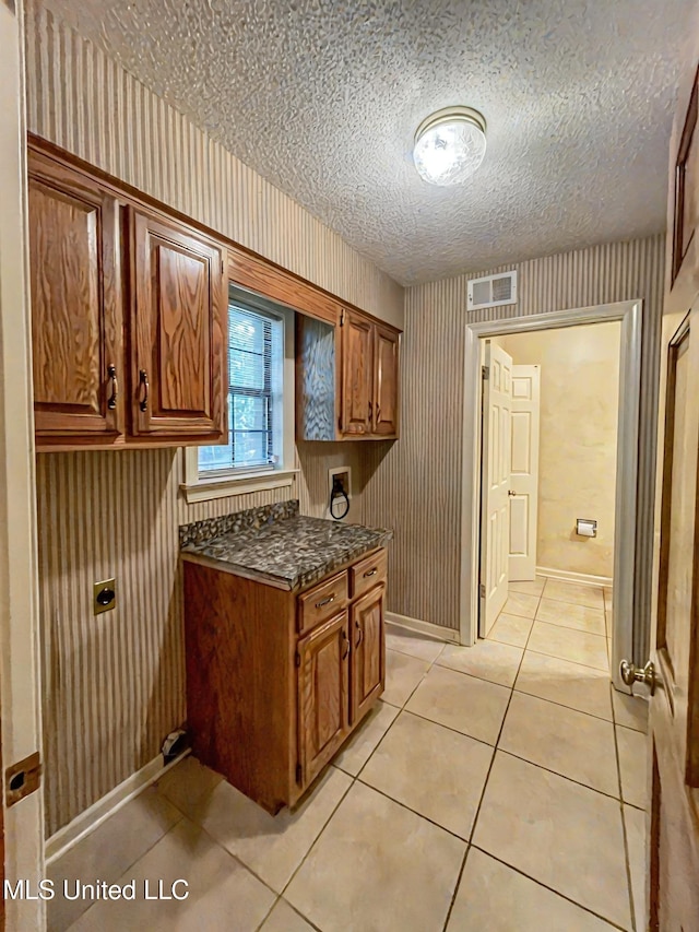 kitchen with a textured ceiling and light tile patterned flooring