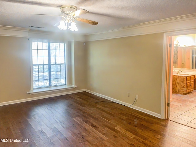 spare room with a textured ceiling, hardwood / wood-style flooring, sink, and ceiling fan