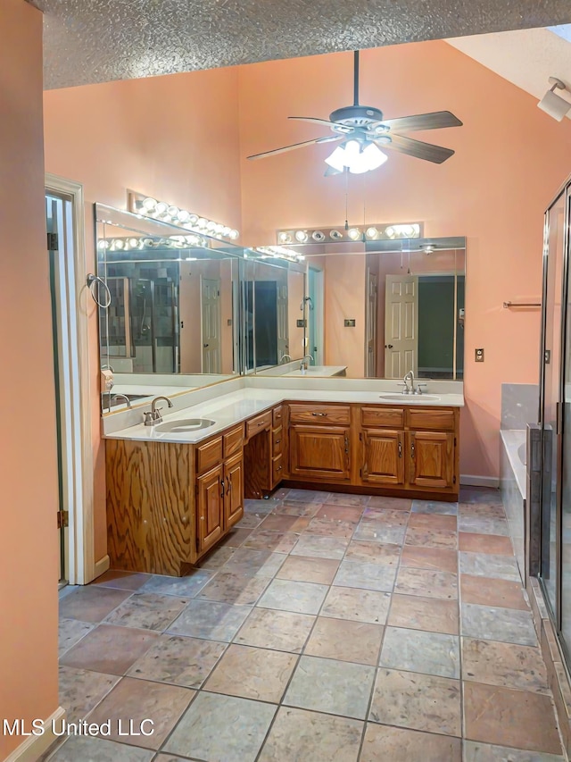 bathroom featuring vanity, lofted ceiling, a textured ceiling, and ceiling fan