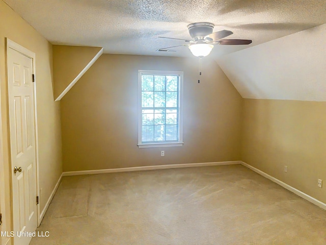 bonus room with light carpet, lofted ceiling, a textured ceiling, and ceiling fan