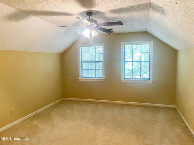 bonus room with carpet flooring, a textured ceiling, lofted ceiling, and ceiling fan