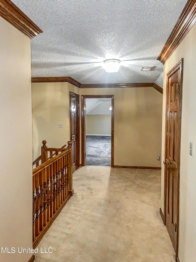 hall featuring crown molding, light carpet, and a textured ceiling