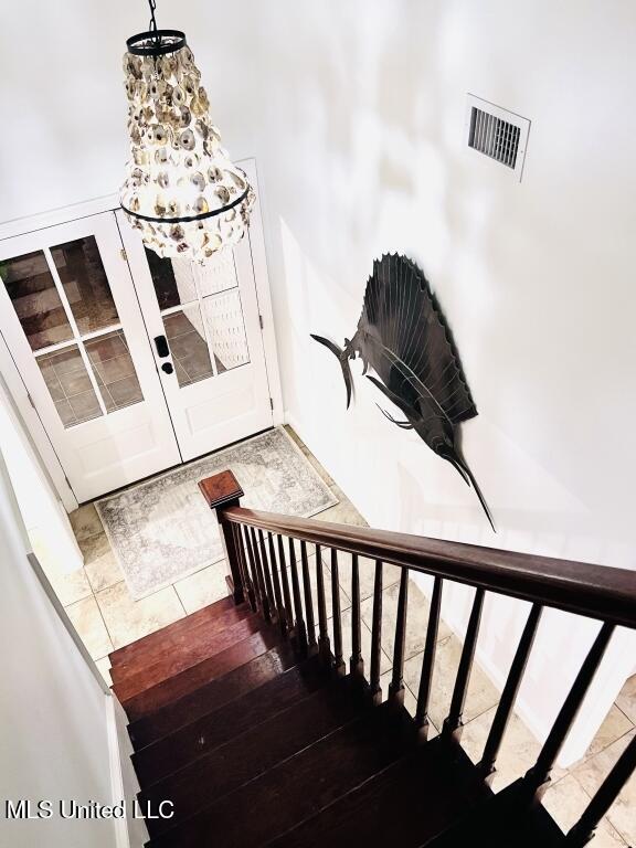 stairs with tile patterned floors and visible vents