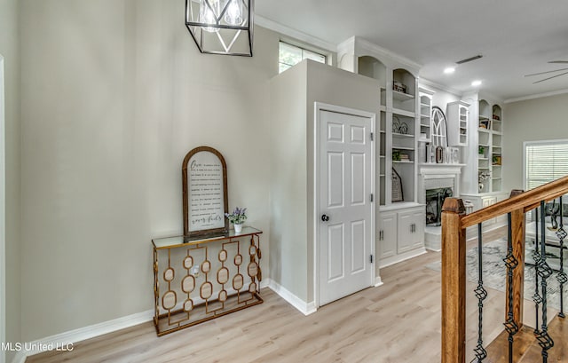 hall with crown molding and light hardwood / wood-style flooring