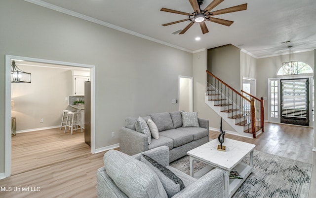 living room with light hardwood / wood-style floors, crown molding, and ceiling fan with notable chandelier