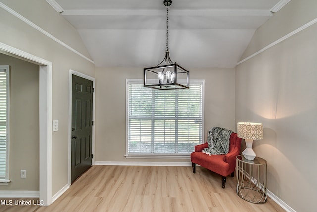 living area with light hardwood / wood-style floors, a chandelier, and vaulted ceiling