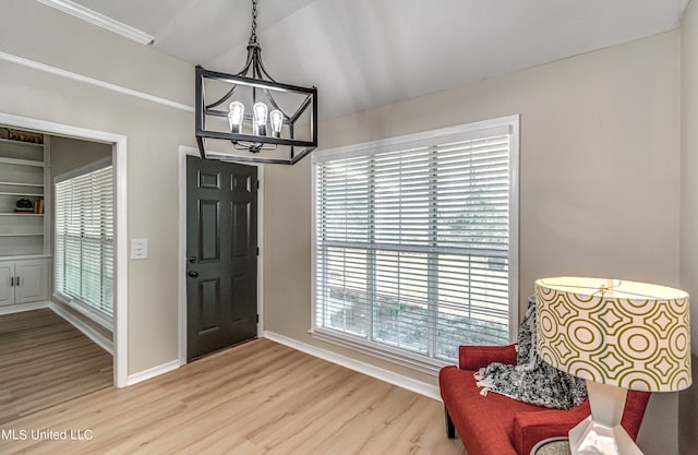 foyer entrance featuring vaulted ceiling, hardwood / wood-style flooring, and an inviting chandelier