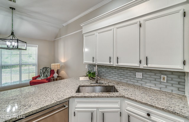 kitchen with hanging light fixtures, ornamental molding, sink, stainless steel dishwasher, and white cabinetry