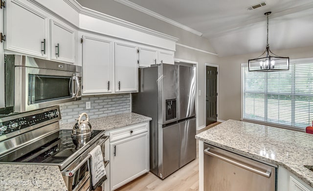 kitchen with lofted ceiling, appliances with stainless steel finishes, white cabinetry, and light hardwood / wood-style floors