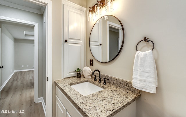 bathroom featuring vanity, crown molding, and hardwood / wood-style flooring