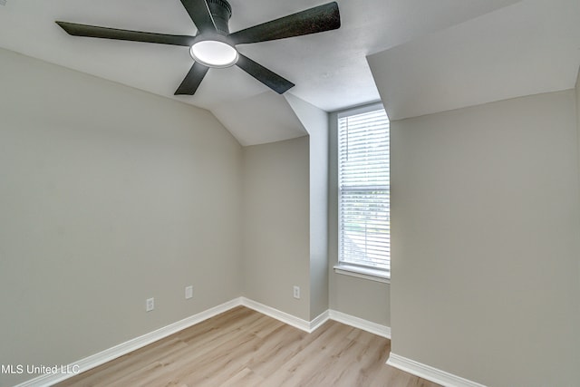 additional living space with ceiling fan, a healthy amount of sunlight, lofted ceiling, and light hardwood / wood-style flooring