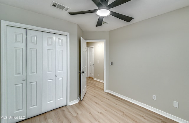 unfurnished bedroom with a closet, light hardwood / wood-style floors, and ceiling fan