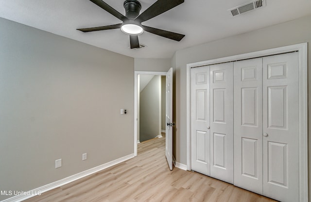 unfurnished bedroom featuring a closet, ceiling fan, and light wood-type flooring