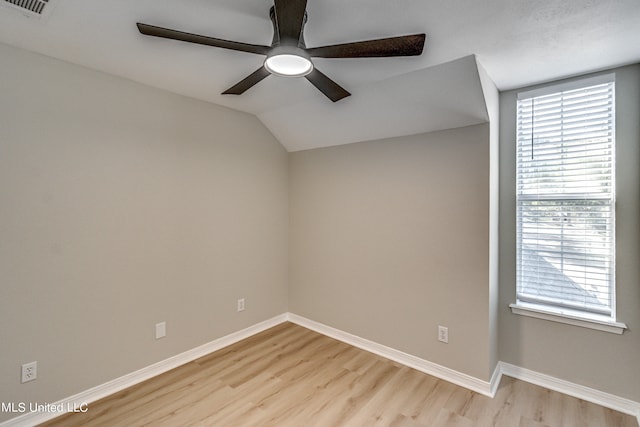 empty room featuring vaulted ceiling, light hardwood / wood-style floors, and ceiling fan