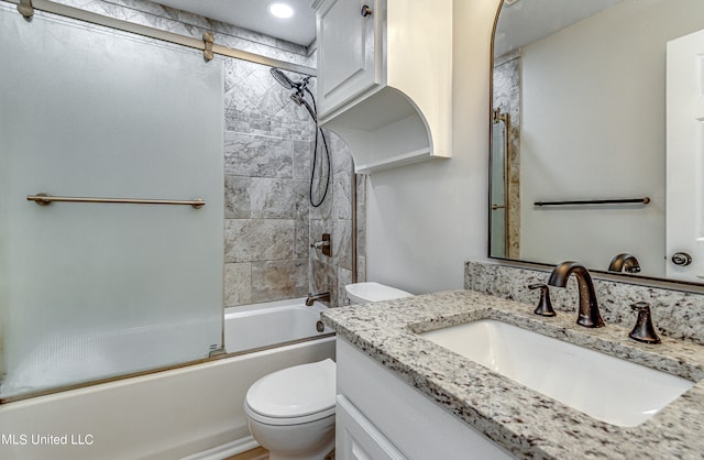 full bathroom with toilet, bath / shower combo with glass door, and vanity