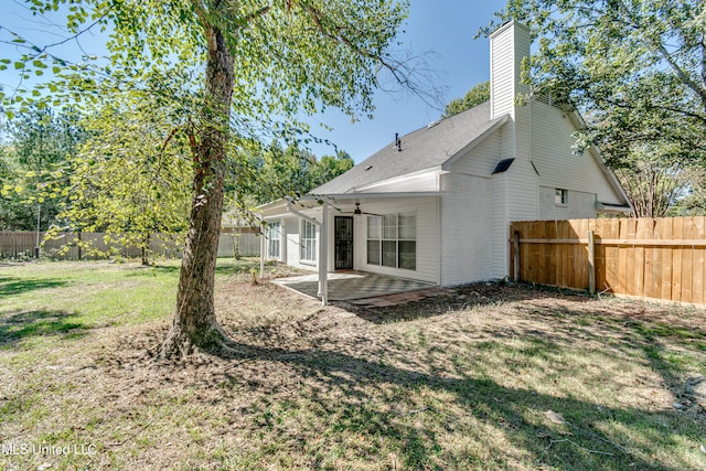 back of house featuring a patio area and a lawn